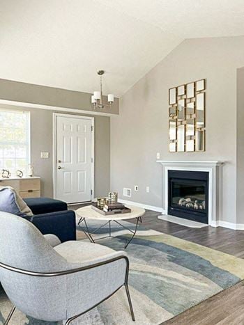 Ranch townhome living room with vaulted ceiling, fireplace, and faux wood flooring